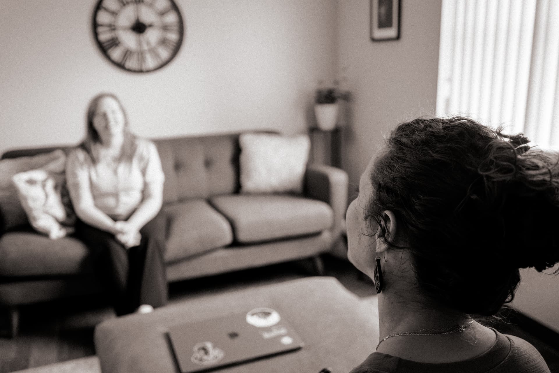 A counselor listening attentively during a session with a client in a softly lit office